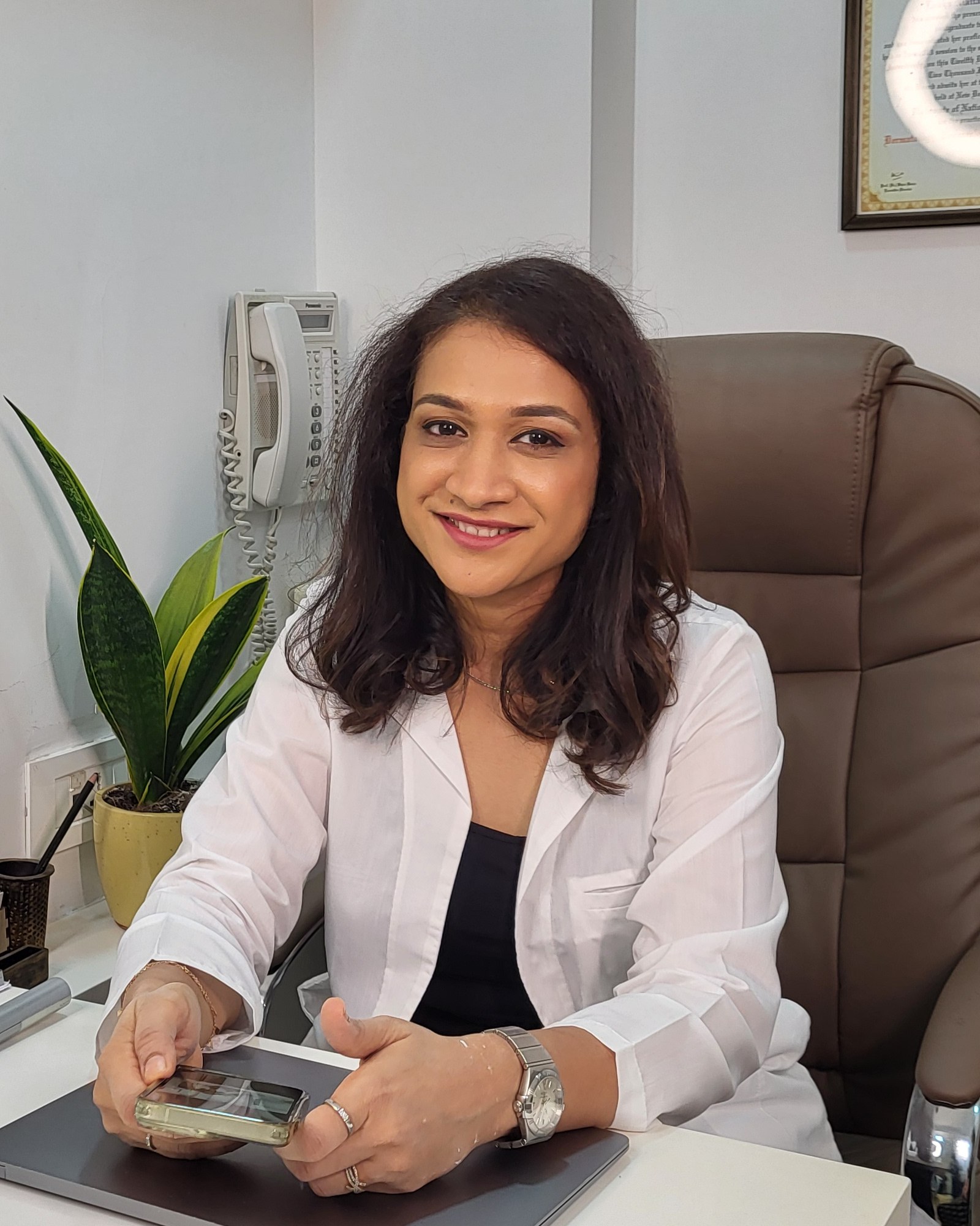 Dr. Nikita Patel, dermatologist at Clear Skin Clinic, at her desk