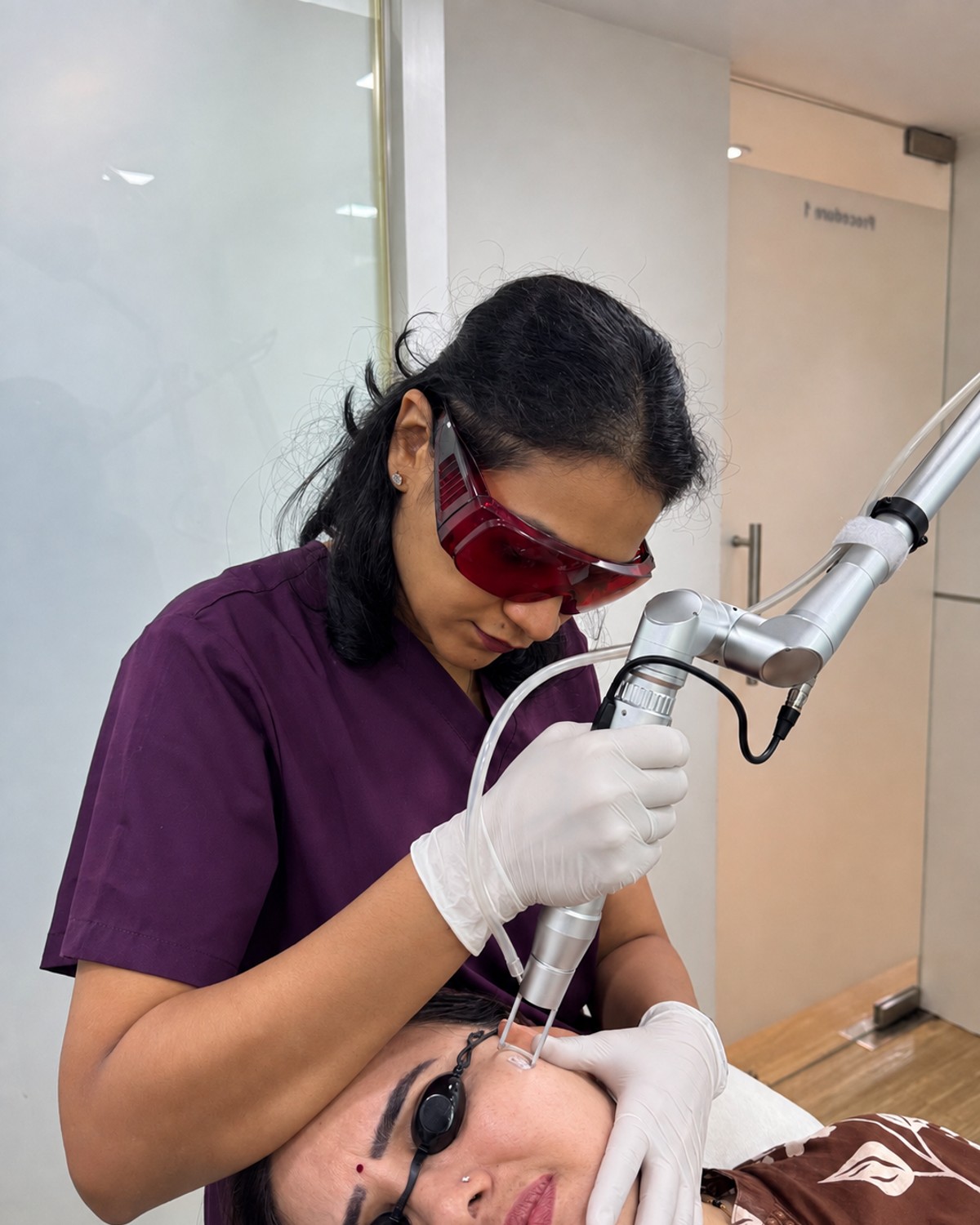Gloved dermatologist performing laser treatment on a patient at Clear Skin Clinic